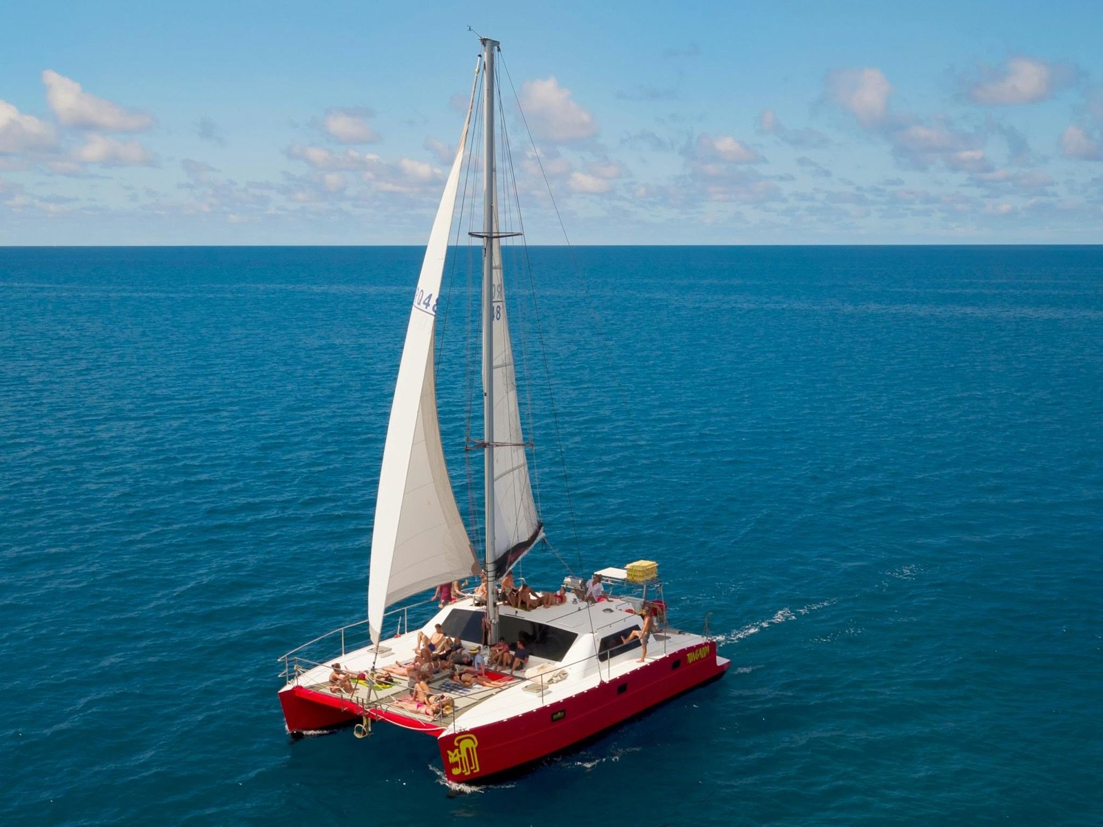 Catamarã vermelho da Tongarra navegando pelas Whitsundays