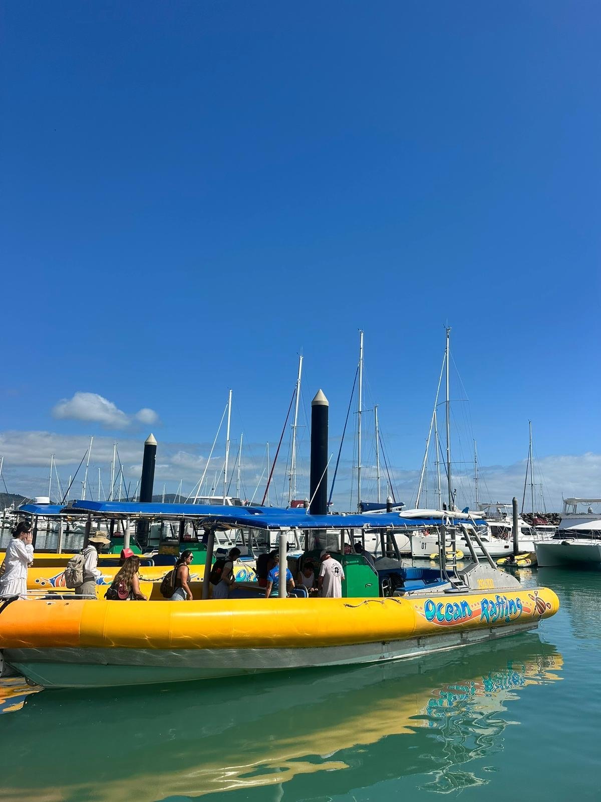 Barco amarelo do Ocean Rafting na marina de Airlie Beach